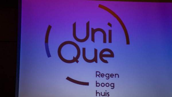 Een projectie van het logo van UniQue op een wit projectiescherm