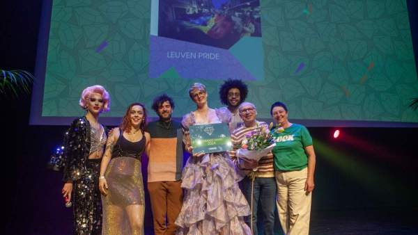 Vrijwilligers van Regenbooghuis UniQue en Queer Leuven samen met Susan from Grindr op het podium van de çavaria awards met de community award voor Leuven Pride